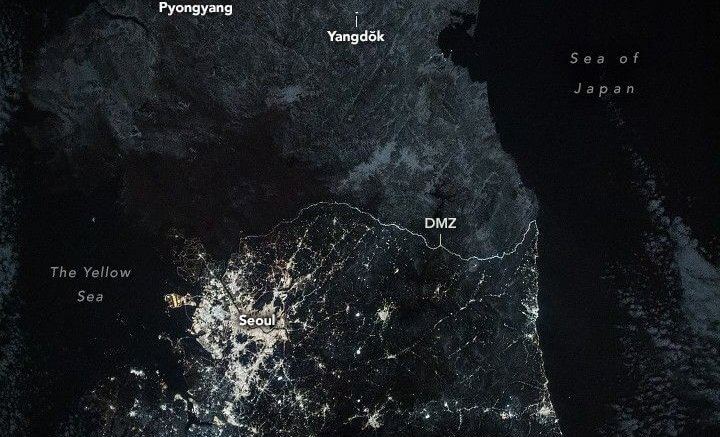 NASA nighttime image of the Korean Peninsula showing South Korea glowing with city lights while North Korea remains largely dark beyond the DMZ.