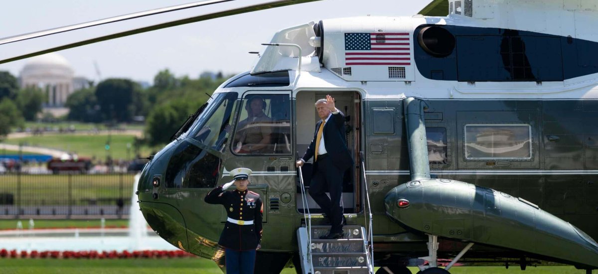 President Donald Trump waves from the steps of Marine One on the South Lawn of the White House, May 12, 2026, departing for a state visit to Beijing as a U.S. Marine renders honors with the Jefferson Memorial in the distance.